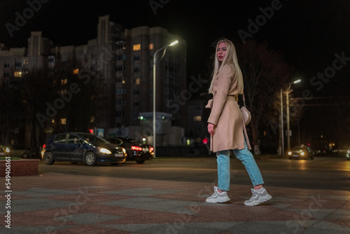 Portrait of a young beautiful fair-haired girl in the night city.