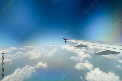 View from airplane window with blue sky and white clouds. Aircraft Wing In Sky. Flying above Krabi, Thailand