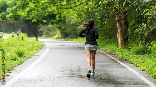 Healthy woman jogging run and workout on road outdoor. Asian runner people exercise gym with fitness session, nature park background. Health and Lifestyle Concept