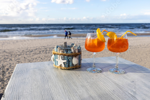 Fototapeta Naklejka Na Ścianę i Meble -  Beach cafe, two drinks on the table. In the background the Baltic Sea and an empty beach, Island Wolin, Miedzyzdroje, Poland