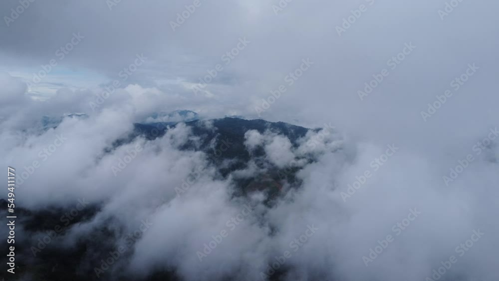 Aerial view of tropical forest with mist in the morning. Top view from drone of beautiful mountain tropical forest during winter in Thailand. Natural landscape background.