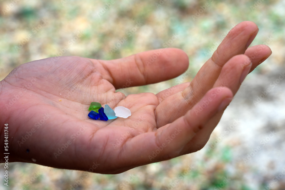 Woman hands holding colored crystals eroded by the sea in the beach of the crystals in the silleiro cape in Pontevedra Woman hands holding colored crystals eroded by the sea in the beach of the crystals in the silleiro cape in Pontevedra