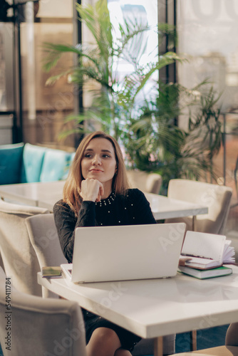 Shot of pretty happy young entrepreneur woman working with laptop sitting in the office.
co-working or modern office or restaurant. 