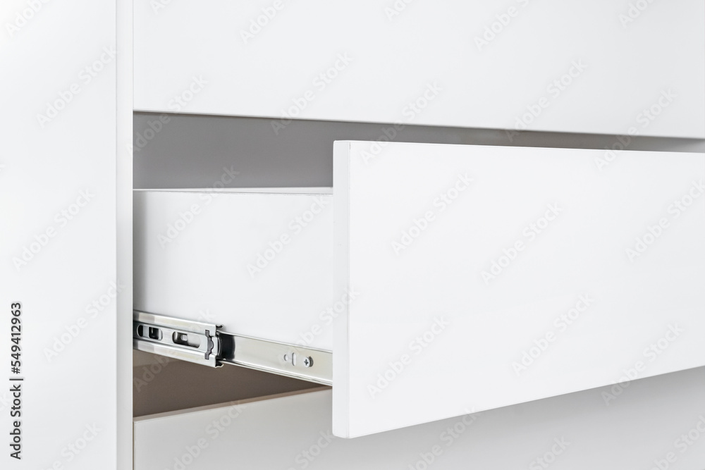 Stainless telescopic bayonet drawer slide guides, installed on a cabinet from white chipboard. Stainless telescopic bayonet drawer slide guides, installed on a cabinet from white chipboard.