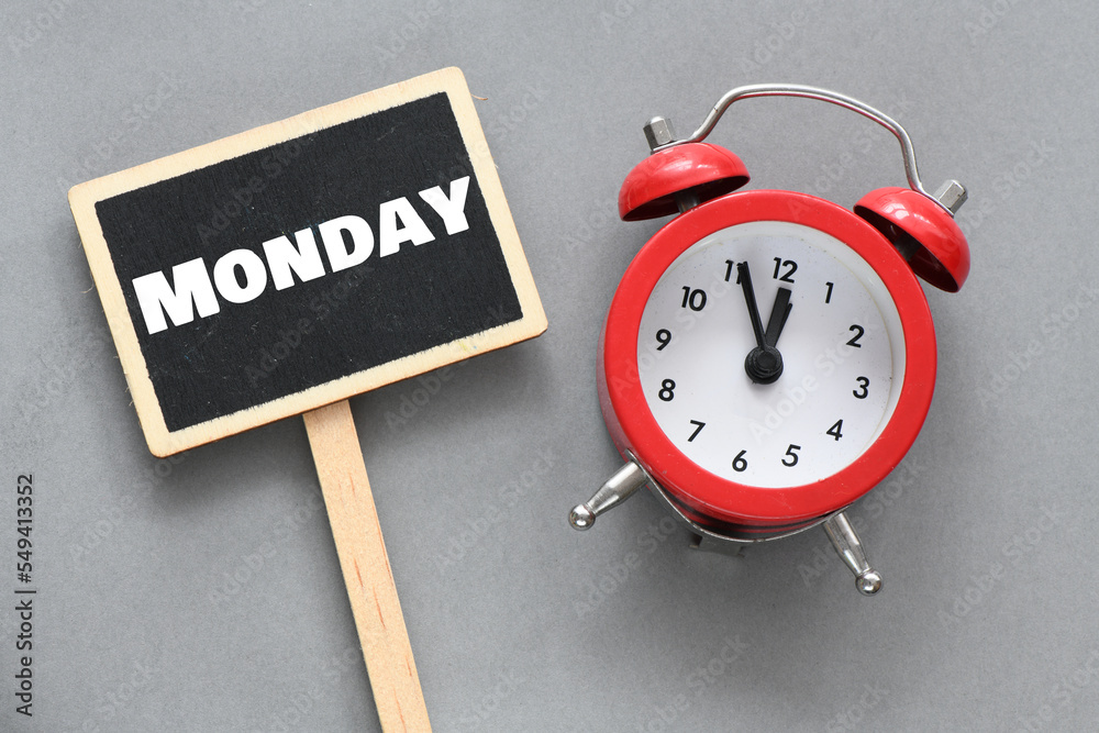 MONDAY word on a small chalkboard next to an alarm clock. MONDAY word on a small chalkboard next to an alarm clock.