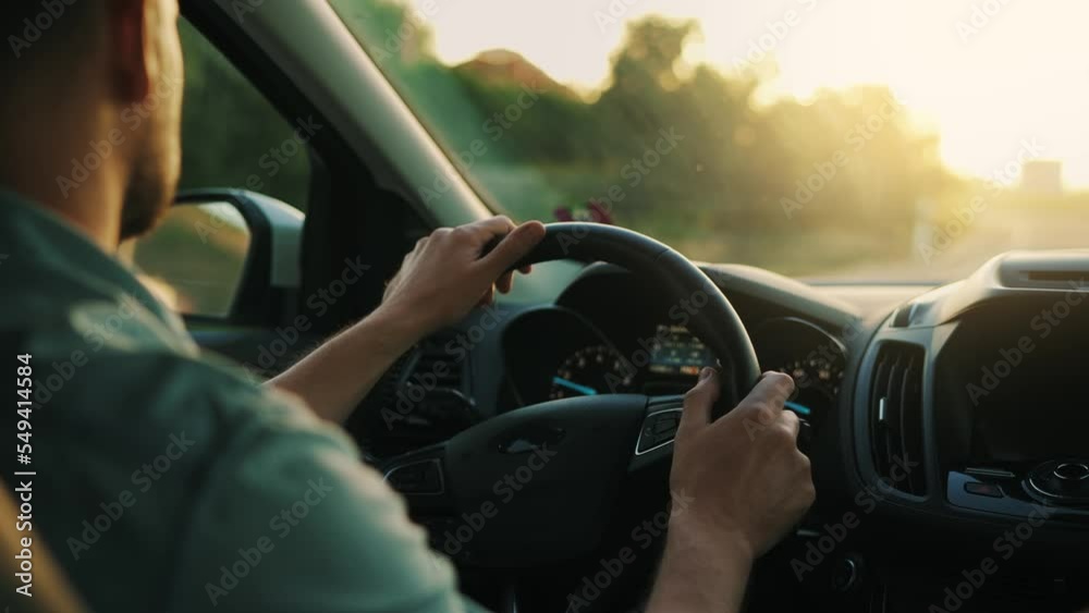 Man drives a car along the road, the setting sun shines in the windshield. Man drives a car along the road, the setting sun shines in the windshield.