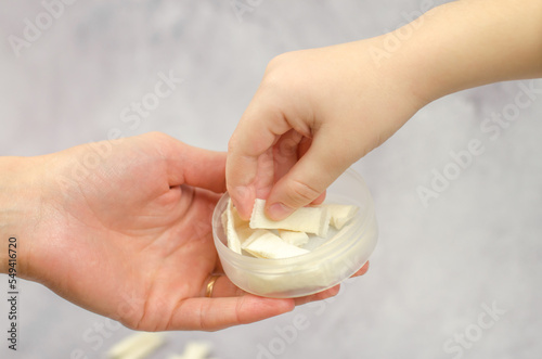 A woman gives Swedish snus to a child, close-up