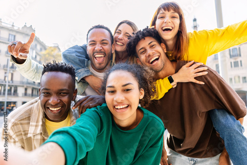 Foto Young group of happy multiracial friends taking selfie portrait in the city