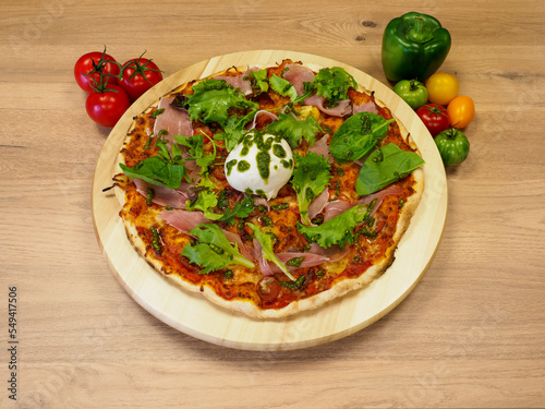 Trés belle pizza appétisante, posé sur un plateau en bois.