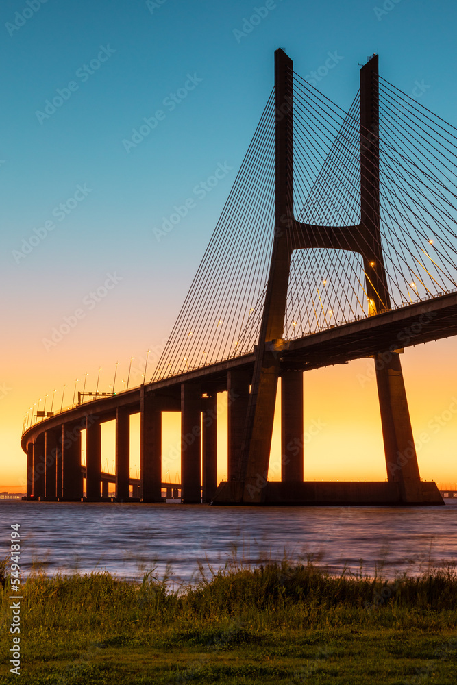 Obraz premium Vasco da Gama bridge at sunrise in a cold November morning: this bridge is simply beautiful, curvy and sexy!
