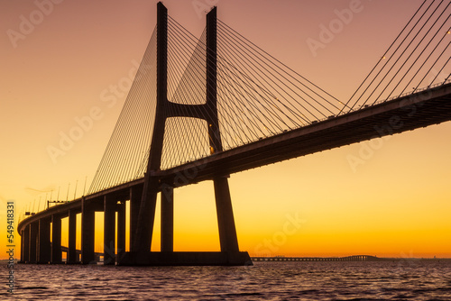 Fototapeta Naklejka Na Ścianę i Meble -  Vasco da Gama bridge at sunrise in a cold November morning: this bridge is simply beautiful, curvy and sexy!