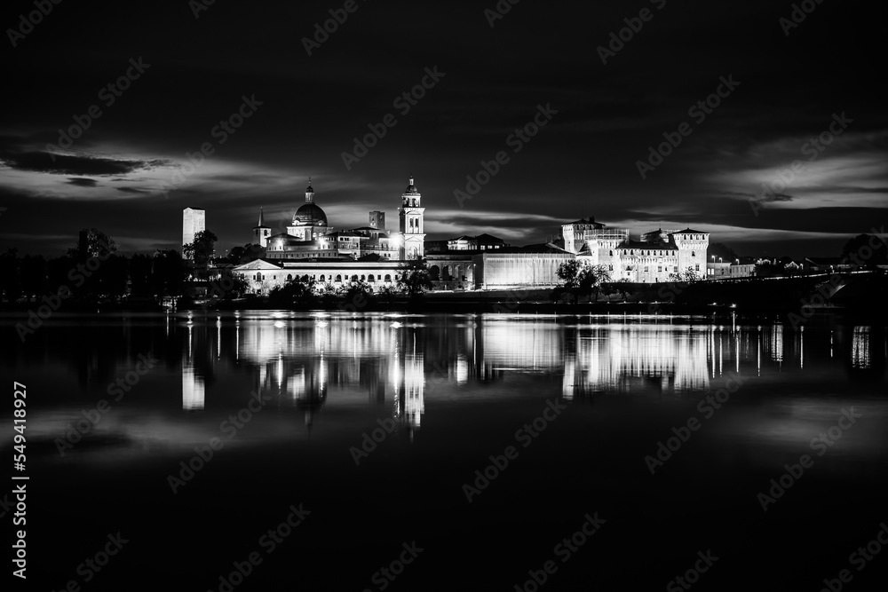 Panoramic evening view of Mantua, Lombardy, Italy; scenic twilight skyline view of the medieval town reflected in the lake waters