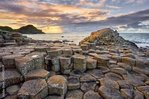 Foto Irish coastline with Volcanic hexagonal basalt columns of Giant`s Causeway at su