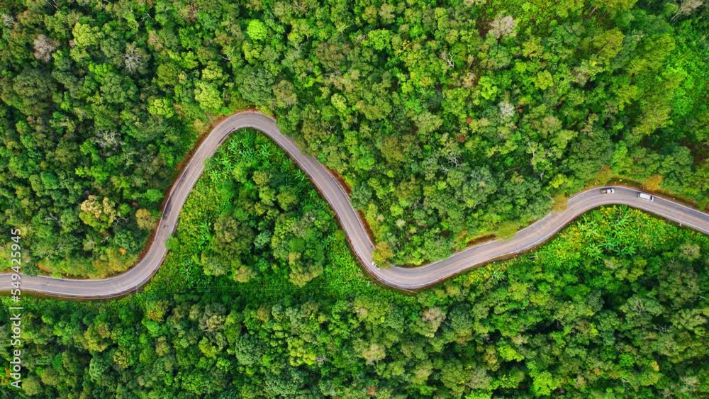 Aerial view over the mountain winding road, amazing road in the green tropical forest. Southeast asia, Thailand. tourism and travel concept. Natural the texture for background. Drone 4K video.
Aerial view over the mountain winding road, amazing road in the green tropical forest. Southeast asia, Thailand. tourism and travel concept. Natural the texture for background. Drone 4K video.