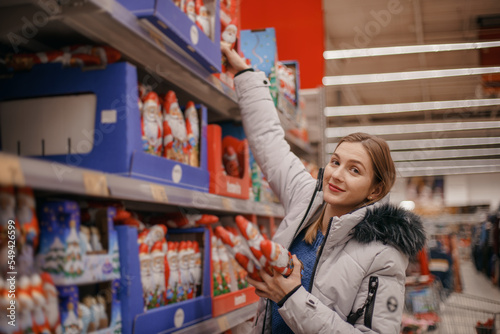 Chocolate Santa Clauses. Mom with a child buys a Chocolate Santa Clauses at the supermarket.