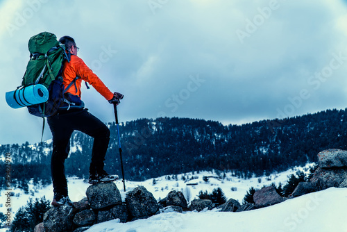 backpacker camper man walking in mountains in winter