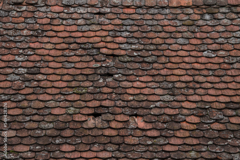 Naklejka premium Ruined tiles on the old house.