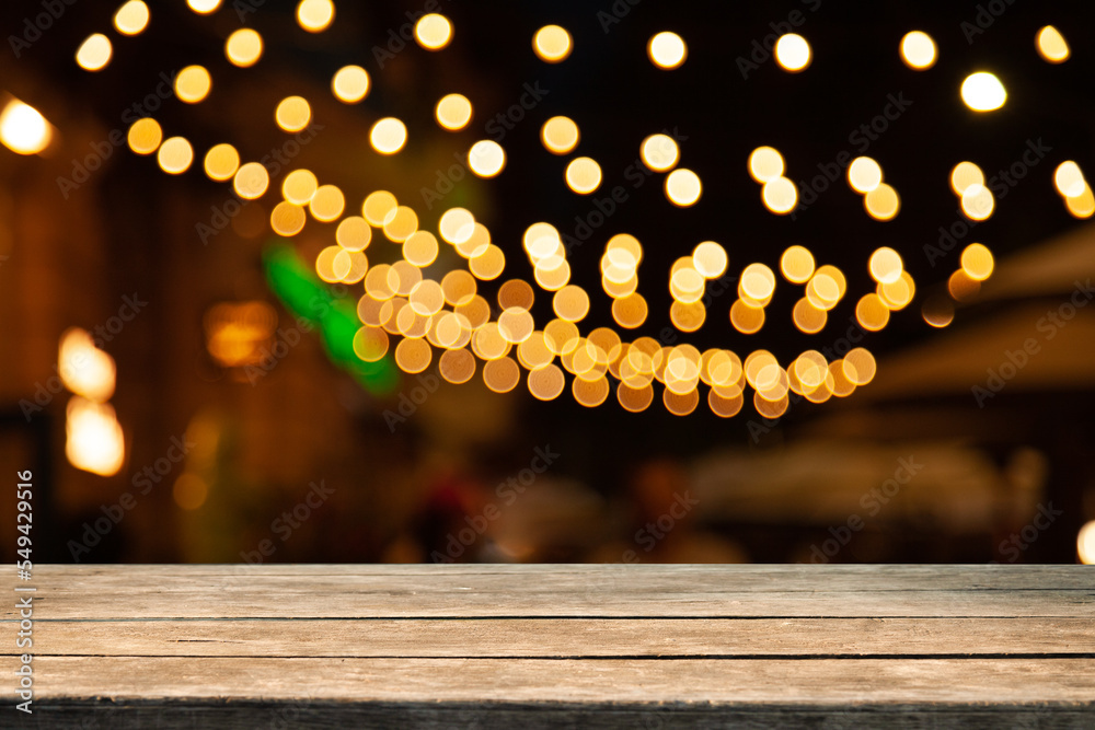 Wooden table top on blurred cafe showcase with light bulb. Background ...