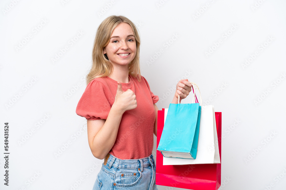 Young English woman isolated on white background holding shopping bags and with thumb up Young English woman isolated on white background holding shopping bags and with thumb up
