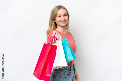 Young English woman isolated on white background holding shopping bags and smiling
