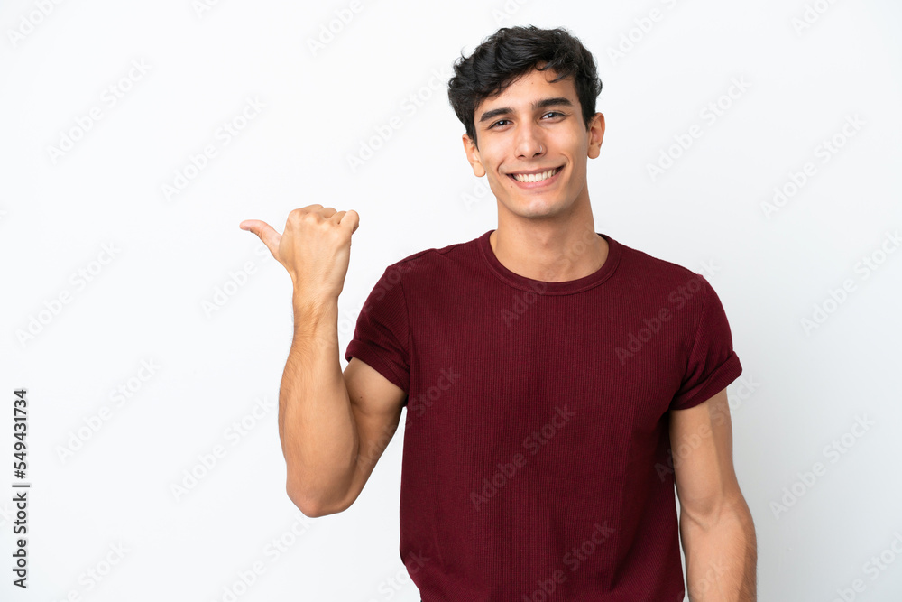 Young Argentinian man isolated on white background pointing to the side to present a product Young Argentinian man isolated on white background pointing to the side to present a product