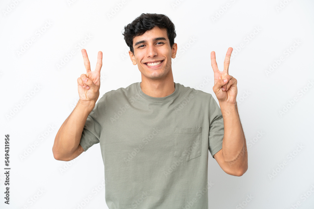 Young Argentinian man isolated on white background showing victory sign with both hands Young Argentinian man isolated on white background showing victory sign with both hands