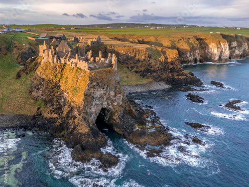 Aerial view with Dunluce Castle  the famous fortress in ruin in Northern Ireland UK  seen at sunrise