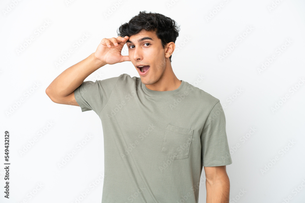 Young Argentinian man isolated on white background doing surprise gesture while looking to the side Young Argentinian man isolated on white background doing surprise gesture while looking to the side