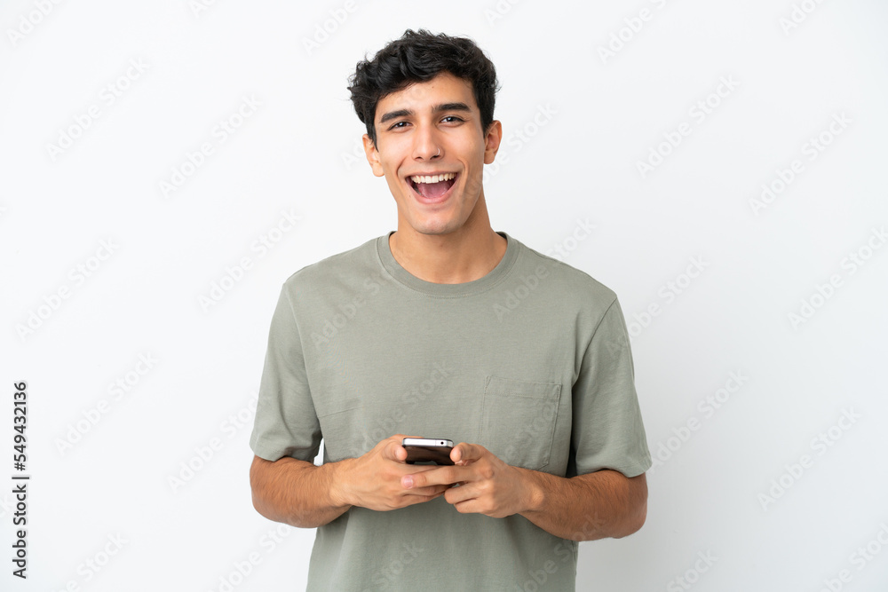 Young Argentinian man isolated on white background surprised and sending a message Young Argentinian man isolated on white background surprised and sending a message
