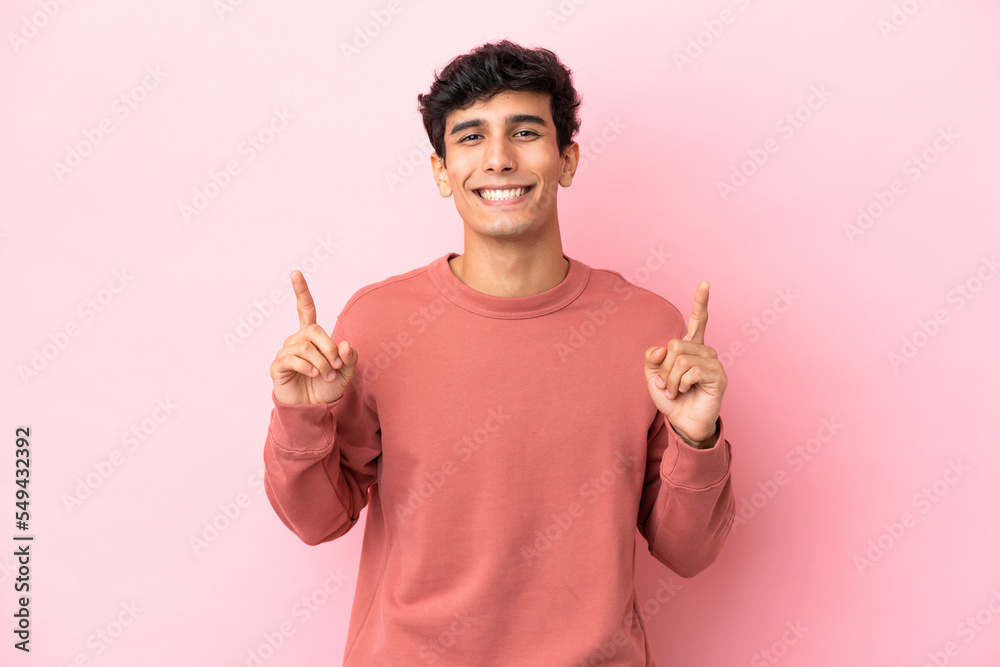 Young Argentinian man isolated on pink background pointing up a great idea Young Argentinian man isolated on pink background pointing up a great idea