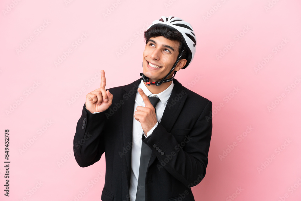 Argentinian businessman with bike helmen isoleted on pink background Argentinian businessman with bike helmen isoleted on pink background
