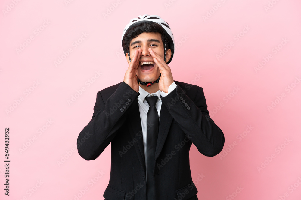 Argentinian businessman with bike helmen isoleted on pink background Argentinian businessman with bike helmen isoleted on pink background