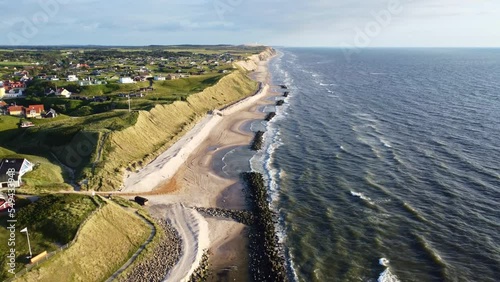 Aerial drone view of the idyllic coast line in Denmark around the village of Lønstrup on a summer day	
