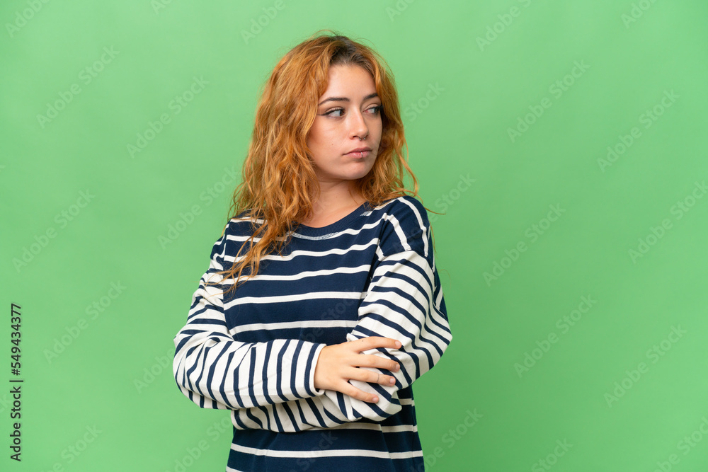 Young caucasian woman isolated on green screen chroma key background keeping the arms crossed Young caucasian woman isolated on green screen chroma key background keeping the arms crossed