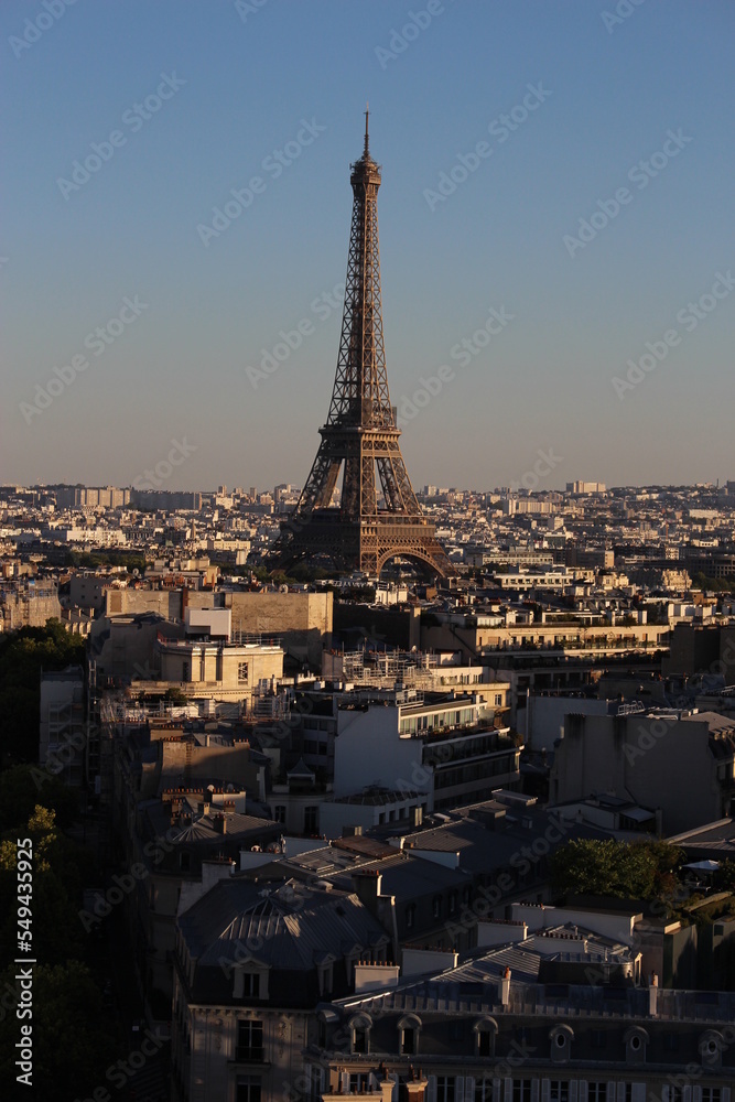 Eiffel tower at golden hour seen among the built up urban Parisian environment. Modern travel background, French concept
