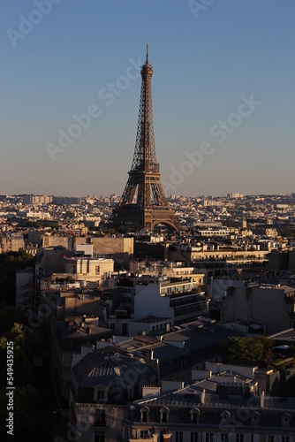 Eiffel tower at golden hour seen among the built up urban Parisian environment. Modern travel background  French concept