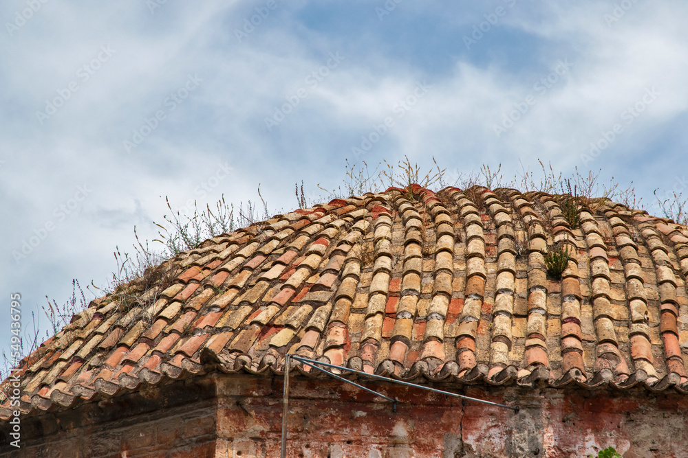 Naklejka premium Tiled roof of old countryside house closeup on sky background