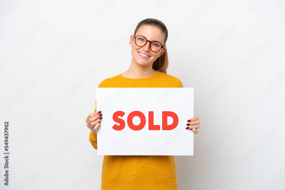Young caucasian woman isolated on white background holding a placard with text SOLD with happy expression Young caucasian woman isolated on white background holding a placard with text SOLD with happy expression