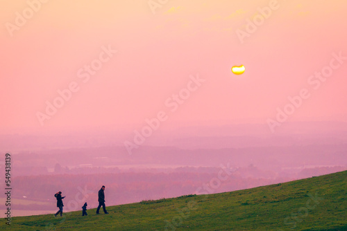 Children playing in the hills at sundset