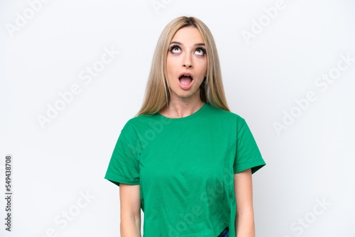Pretty blonde woman isolated on white background looking up and with surprised expression
