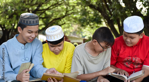 Canvas Print Group of muslim boys sit together under the tree in the school park, they also read, learn, talk, suggest and consult learning problems to each other, soft and selective focus