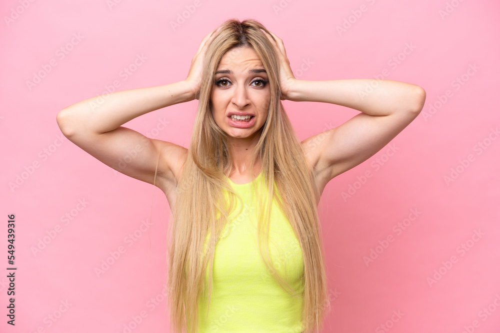 Pretty blonde woman isolated on pink background doing nervous gesture