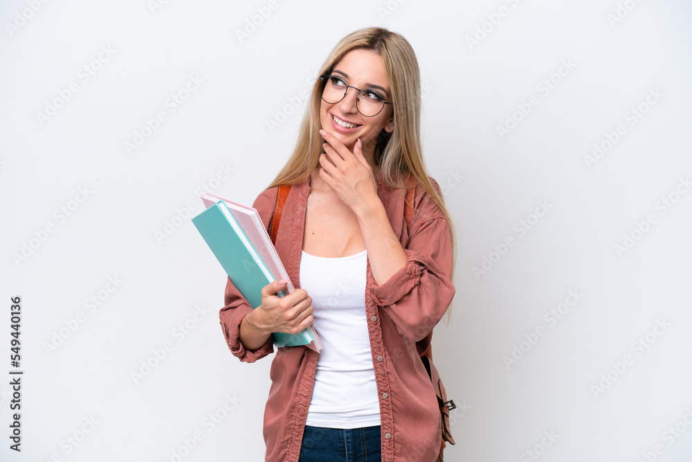 Pretty student blonde woman isolated on white background looking up while smiling Pretty student blonde woman isolated on white background looking up while smiling