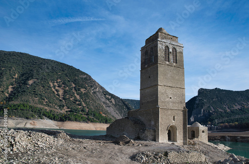 The reservoir with the tower of the church of the Assumption emerged due to drought and lack of rainfall.  Climate change. Autumn 2022. Huesca, Spain.