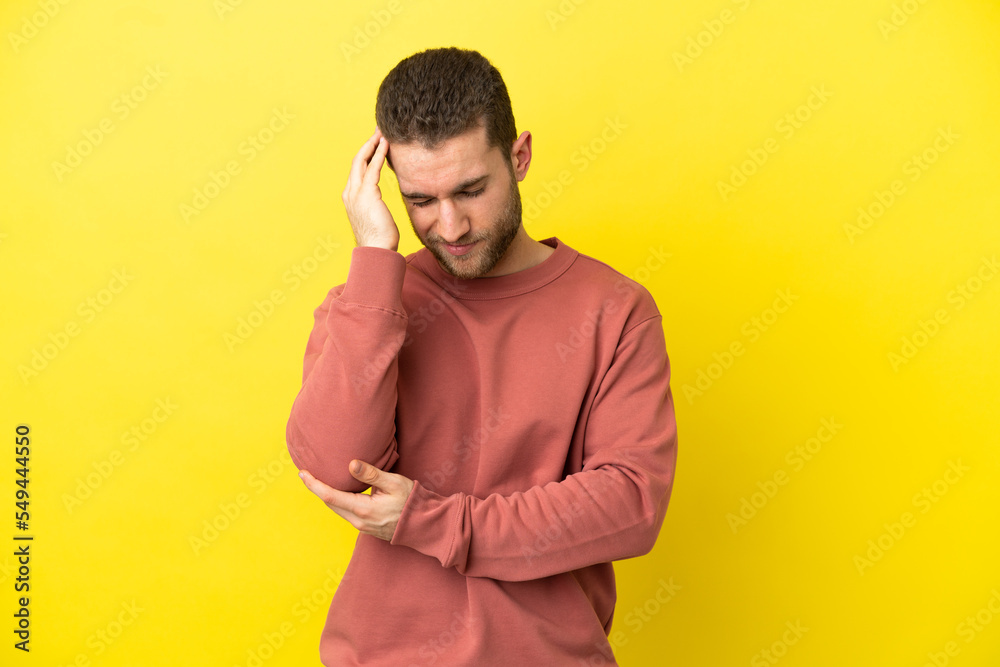Handsome blonde man over isolated yellow background with headache Handsome blonde man over isolated yellow background with headache
