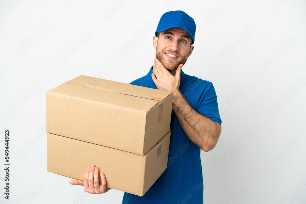 Delivery man over isolated white background looking up while smiling Delivery man over isolated white background looking up while smiling