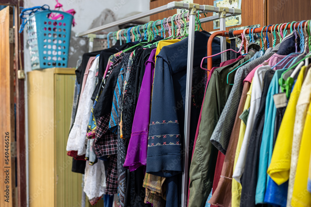 Lots of old, colorful clothes hung chaotically on the iron railings near the closets.