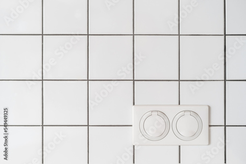 electrical sockets with lid on white tile wall indoors