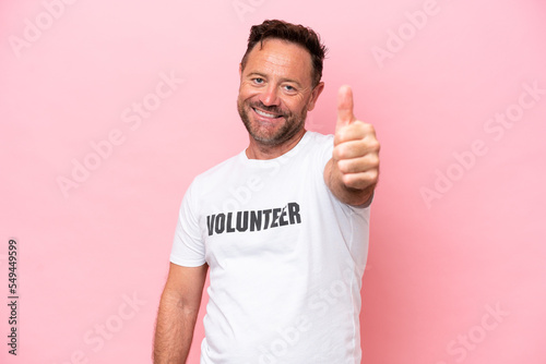 Middle age volunteer man isolated on pink background isolated on pink background with thumbs up because something good has happened
