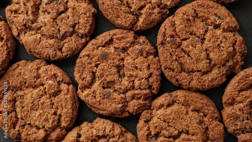 Fresh oatmeal cookies rotating. Food concept. Homemade cookies with chocolate. Stack of whole meal cookies. Top view. Close-up in 4K, UHD